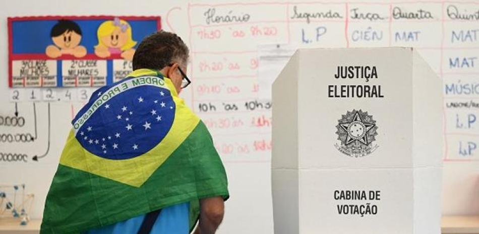 Votante brasileño en colegio electoral. AFP