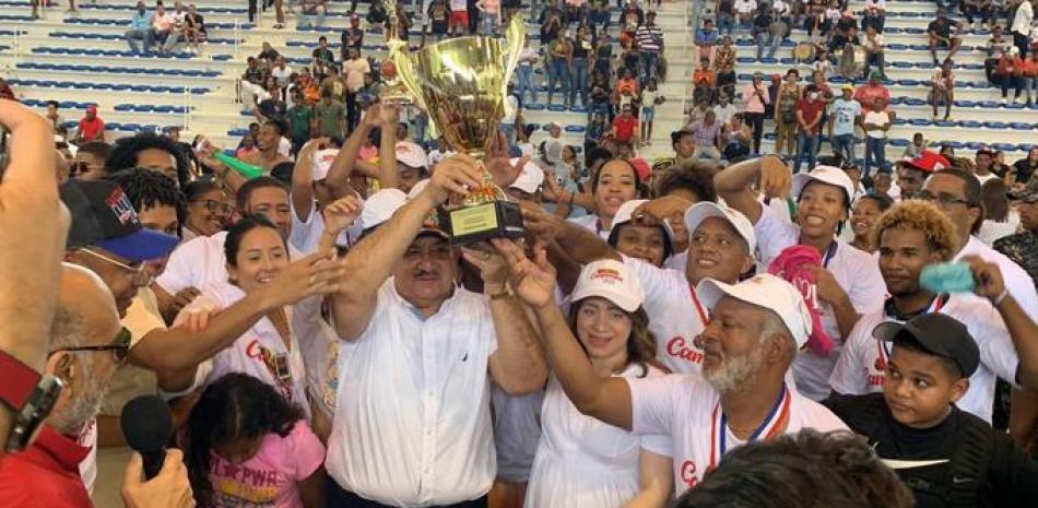 La presidenta del Comité Organizador del campeonato de la LNBF, Gloria Reyes entrega el trofeo al equipo de las Reinas del Este, que recibe el Senador de la provincia Cristóbal Castillo.