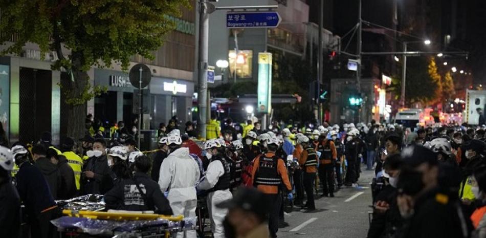 Ambulancias y rescatistas llegan a la calle cerca de la escena de una multitud en Seúl, Corea del Sur, el domingo 30 de octubre de 2022. AP