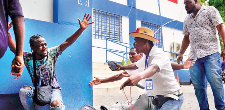 El periodista haitiano Romelo Vilsaint, quien falleció tras ser baleado, yace boca abajo en el estacionamiento de un departamento policial de Puerto Príncipe, Haití, el domingo pasado. / AP