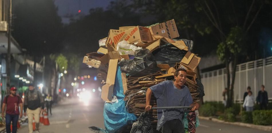 Un hombre tira de un carrito de artículos reciclables para vender en el centro de Sao Paulo, Brasil, el martes 18 de octubre de 2022. El FMI dijo el miércoles que la actividad económica de América Latina se reducirá desde fines de 2022 y en 2023, principalmente por el endurecimiento monetario y financiero internacional. (Foto AP/Andre Penner)