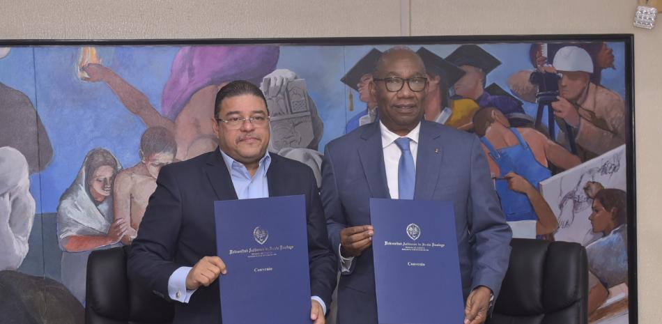Francisco Camacho, ministro de Deportes, y Editrudis Beltrán, rector de la UASD, muestran las carpetas con el acuerdo.