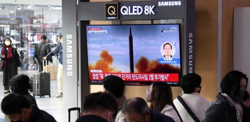 En esta foto de archivo tomada el 3 de noviembre de 2022, la gente mira una pantalla de televisión que muestra una emisión de noticias con imágenes de archivo de una prueba de misiles de Corea del Norte, en una estación de tren en Seúl. Foto: Jung Yeon-je/AFP.