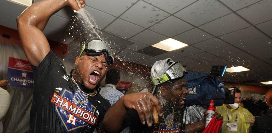 Los dominicanos Framber Valdez y Héctor Neris son bañados de champagne durante la celebración de los Astros este sábado como campeones mundiales de las Grandes Ligas.