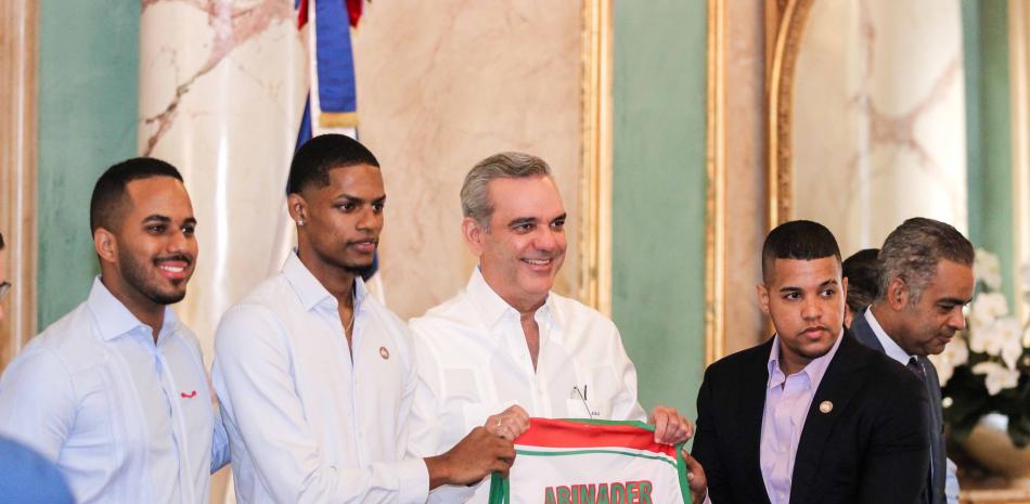 El presidente Luis Abinader sostiene una camiseta junto al capitán del equipo de Bameso Miguel Dicent.
