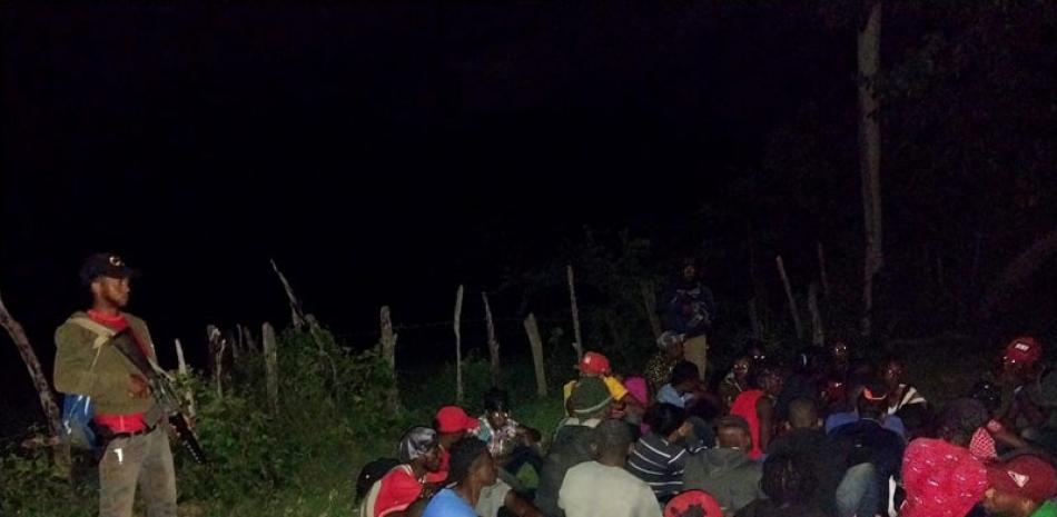 Una militar dominicano asignado a la protección de la frontera vigila a un grupo de ilegales haitianos capturados, apenas haber ingresado a territorio nacional. / Archivo