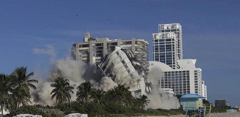 El domingo 13 de noviembre de 2022 la torre del hotel de 17 pisos del histórico Deauville Beach Resort implosiona arrojando una gran cantidad de polvo y escombros a los edificios de lujo situados junto al océano. (Carl Juste/Miami Herald vía AP)