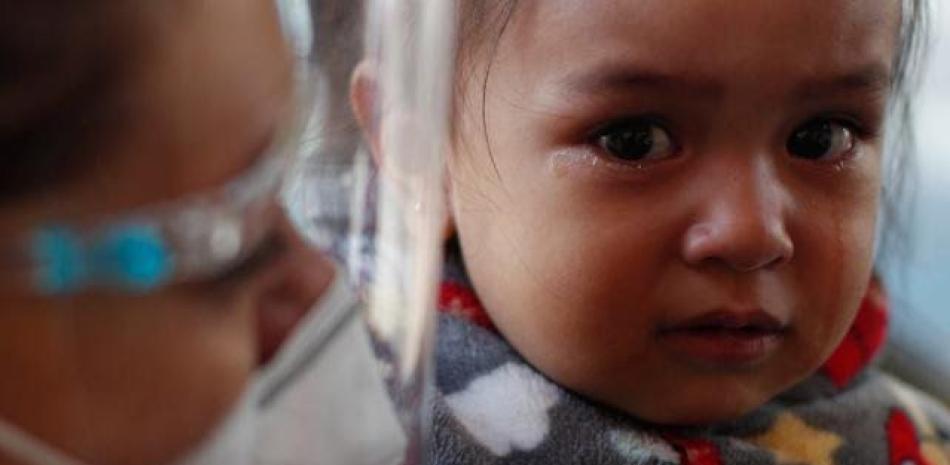 Una niña llora mientras su madre la prepara para recibir la vacuna contra la gripe en Ciudad de México.  La OPS dijo ayer que algunas enfermedades respiratorias están resurgiendo de forma atípica en las Américas. AFP