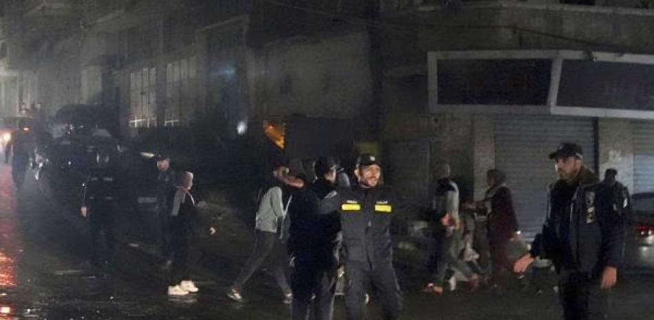 Agentes de policía de Hamas acordonan la escena de un incendio, en un edificio de tres plantas en el campo de refugiados de Jebaliya. AP