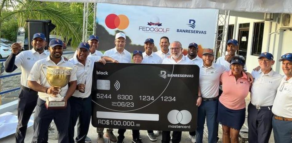 Kelvin García del Banco de Reservas y Carlos Elmúdesi, de Fedogolf entregan la copa a los campeones Asoglar y un cheque simbólico de 100 mil pesos.