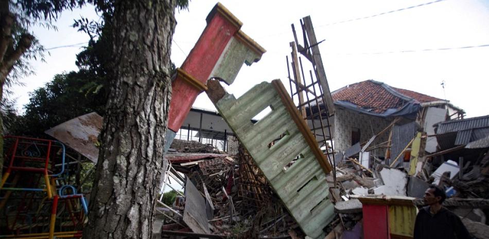 Un hombre junto a casas dañadas tras un terremoto en Cianjur el 21 de noviembre de 2022. Al menos 56 personas murieron en un terremoto que sacudió la isla principal de Java, Indonesia, el 21 de noviembre de 2022, dijo el gobernador de la provincia más afectada.
STR / AFP