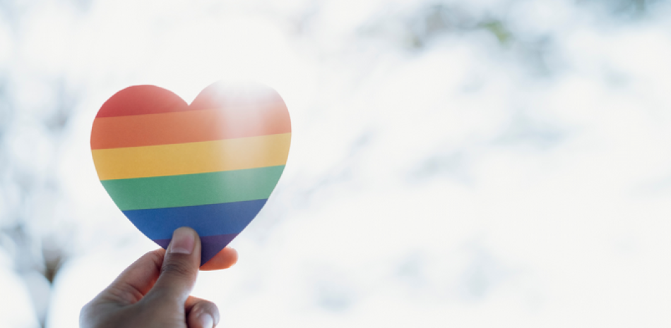 Mano sosteniendo corazón del arco iris LGBTQ