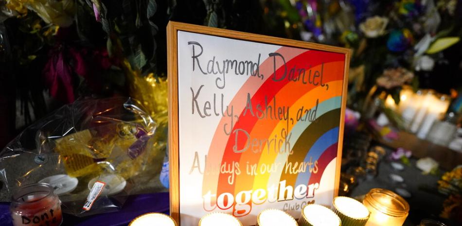 Los nombres de las víctimas se muestran en un arcoíris durante una vigilia con velas en una esquina cerca del sitio de un tiroteo masivo de fin de semana en un bar gay, el lunes 21 de noviembre de 2022. AP.
