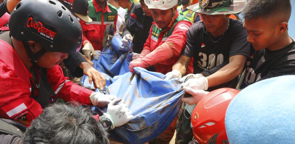 Rescatistas retiran el cuerpo de una víctima recuperada de debajo de los escombros en una aldea afectada por un deslizamiento de tierra provocado por un terremoto en Cianjur, Java Occidental, Indonesia, el martes 22 de noviembre de 2022. (Foto AP/Rangga Firmansyah)