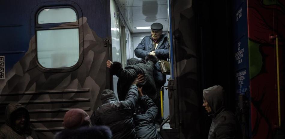 Ucranianos abordan un tren de Jersón a Kiev, el lunes 21 de noviembre de 2022, en la estación de trenes de Jersón, en el sur de Ucrania. (AP Foto/Bernat Armangue