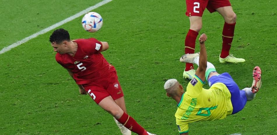 Richarlison, de Brasil, conecta el balón cerca del defensor de Serbia Milos Veljkovic para anotar el segundo gol de su equipo en el partido del Grupo G del Mundial de Fútbol.