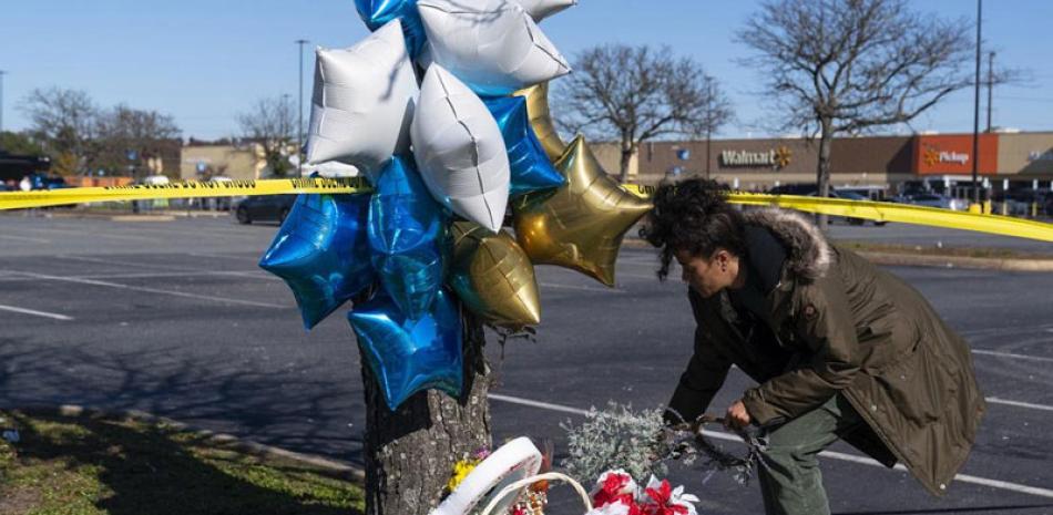 Shyleana Sausedo-Day, de Portsmouth, Virginia, coloca flores el miércoles 23 de noviembre de 2022 cerca del lugar donde la noche anterior fue perpetrada una masacre a tiros en un Walmart, en Chesepeake, Virginia. AP