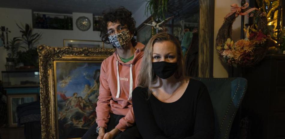 Carey Johnson y su hijo Fabian Swain son fotografiados con mascarillas en su casa de Germantown, Maryland, el lunes 14 de noviembre de 2022. Tanto Carey como Fabian se han recuperado de COVID. (Foto AP/Carolyn Kaster)