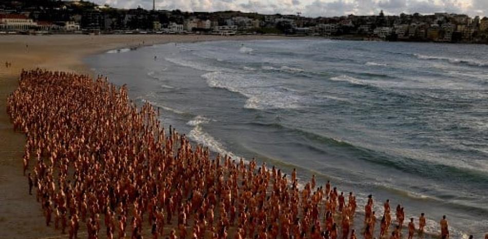 Participants pose nude during sunrise on Sydney's Bondi Beach for US art photographer Spencer Tunick, to raise awareness for skin cancer, on November 26, 2022. Saeed KHAN / AFP
