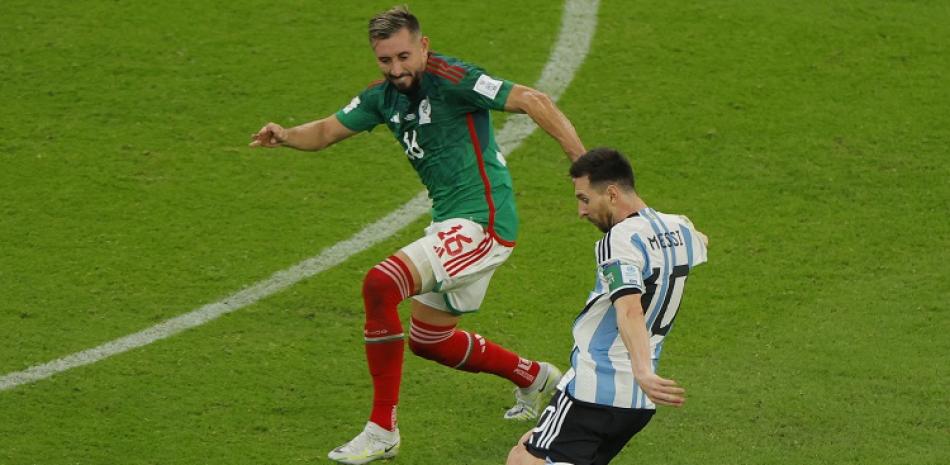 Lionel Messi, de Argentina, conecta una patada ante Héctor Herrera, de México, para anotar el primer gol de su equipo en el partido del Grupo C del Mundial de Fútbol.