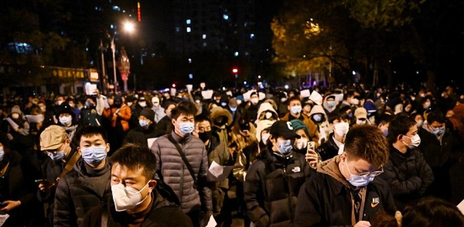 Los manifestantes marchan por una calle durante una manifestación por las víctimas de un incendio mortal, así como una protesta contra las duras restricciones de China por el covid-19 en Beijing el 28 de noviembre de 2022. AFP