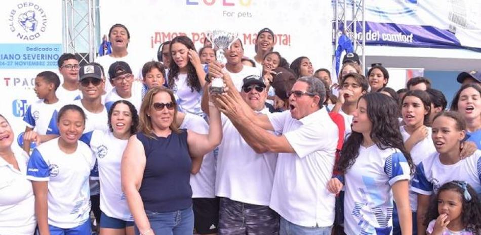 Madelaine Andino, primera vicepresidenta del club Naco entrega el trofeo de campeón a los nadadores de los Delfines de Naco.