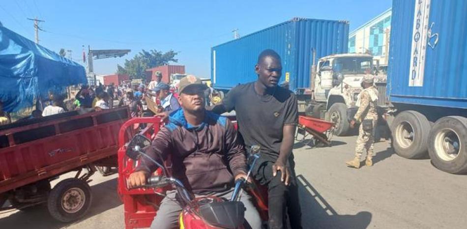 Los haitianos utilizan motocicletas de tres ruedas para llevar alimentos.