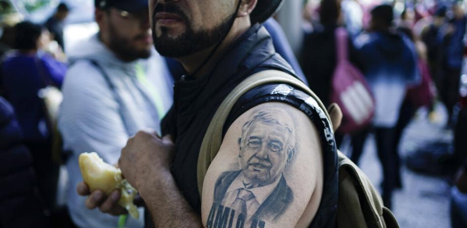 Un partidario del presidente mexicano, Andrés Manuel López Obrador, luciendo un tatuaje del presidente, se reúne con otros antes de una marcha para apoyar la administración de López Obrador, en la Ciudad de México, el domingo 27 de noviembre de 2022.