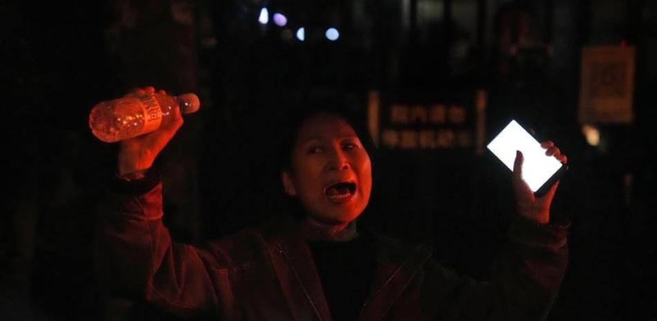 Una mujer grita durante una protesta en Pekín el domingo pqasado. Las autoridades chinas suavizaron las medidas contra el virus en algunos lugares pero se reafirmaron hoy en la rígida estrategia “cero COVID” del país, ayer. AP
