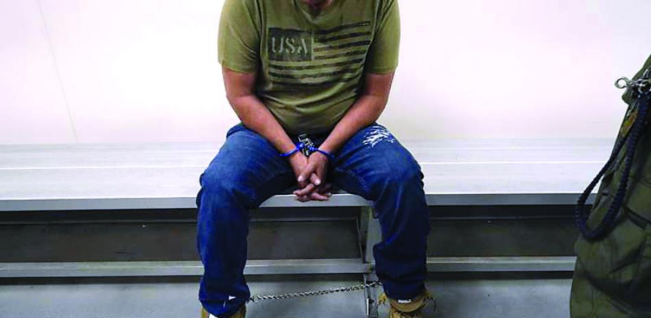 Un inmigrante aguarda a ser procesado por agentes de inmigración en un centro de detención migratorio en Los Ángeles, el 6 de enero de 2022. AP