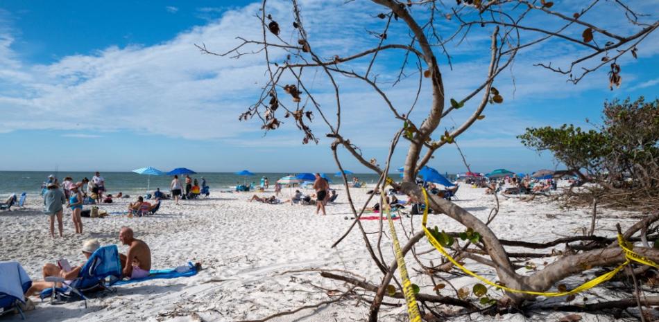 La gente disfruta de una tarde en una playa de Naples el 23 de noviembre de 2022 en Naples, Florida. A pesar de los continuos cierres y advertencias en muchas playas del Golfo de México, Florida, luego de la devastación provocada por el huracán Ian, los turistas y los lugareños han regresado lentamente a las playas a medida que abren. Spencer Platt/Getty Images/AFP