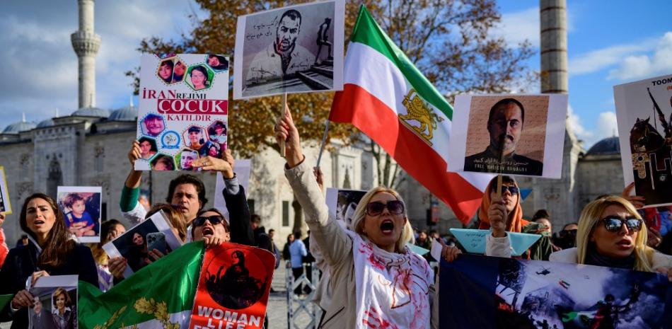 Las personas sostienen pancartas con retratos del disidente iraní Hossein Ronaghi (R) y el rapero iraní Toomaj Salehi (Top-C), quienes son arrestados en Irán, mientras participan en una manifestación en apoyo de las mujeres iraníes en Estambul, el 26 de noviembre de 2022 Ronaghi es uno de las docenas de destacados activistas de derechos, periodistas y abogados arrestados en la represión de las protestas que estallaron después de la muerte de Mahsa Amini, luego de su arresto por parte de la policía moral, según grupos de derechos con sede fuera de Irán.
Yasin AKGUL / AFP