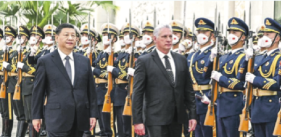 El presidente chino, Xi Jinping, a la izquierda, y el mandatario cubano, Miguel Díaz-Canel Bermúdez, pasan revista a una guardia de honor en Pekín. AP