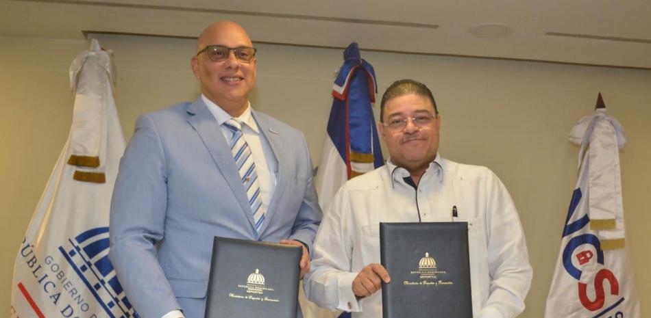 Juan Gabriel Gautreaux Martínez, director ejecutivo del CNCS, y el ministro de Deportes, Francisco Camacho Rivas, presentan el convenio interinstitucional.
