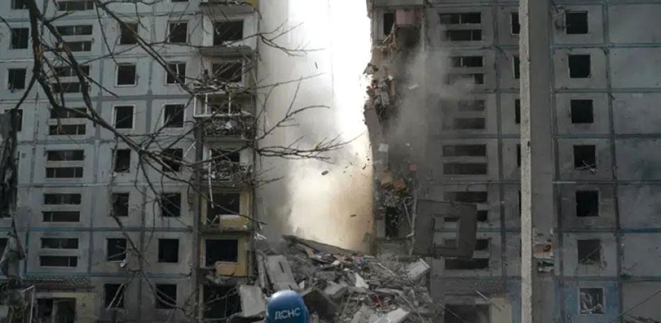 Un bombero observa cómo se derrumba parte de un muro de un edificio residencial que quedó muy dañado tras un ataque ruso en Zaporiyia, el 9 de octubre de 2022. AP