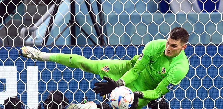 El portero Dominik Livakovic detiene uno de los tres penales que paró en el triunfo de Croacia contra Japón en los octavos de final del Mundial de Fútbol en Catar.