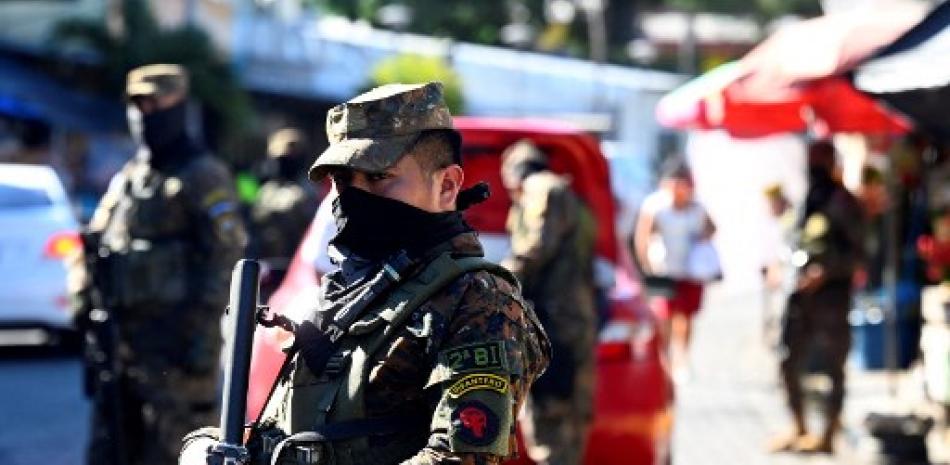 Soldados patrullan locales comerciales en busca de pandilleros durante un operativo contra bandas criminales, en Soyapango, El Salvador, el 5 de diciembre de 2022. AFP