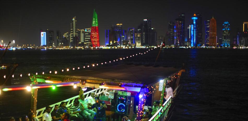 La gente baila en un bote de madera en el paseo marítimo Corniche en Doha, Qatar, el viernes 18 de noviembre de 2022. La pesca de perlas impulsó la economía de Qatar hasta la década de 1930. AP