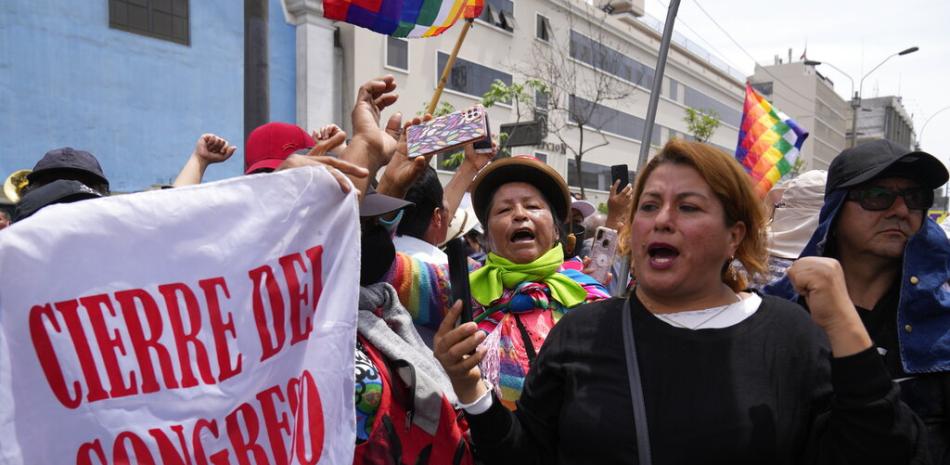 Seguidores del presidente peruano Pedro Castillo protestan portando una bandera que dice "cierre del Congreso" el día en que estaba prevista una sesión para destituir al presidente, cerca del Congreso en Lima, Perú, el miércoles 7 de diciembre. AP