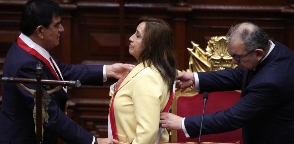 La exvicepresidenta Dina Boluarte recibe la banda presidencial tras prestar juramento como nueva presidenta en el Congreso en Lima, Perú, el miércoles 7 de diciembre de 2022. El Congreso de Perú votó para destituir alpresidente Pedro Castillode su cargo el miércoles y reemplazarlo con la vicepresidenta poco después de que Castillo intentara disolver la Legislatura. A la izquierda, el presidente del Congreso, José Williams, ya la derecha, José Cevasco. (AP Foto/Guadalupe Pardo)