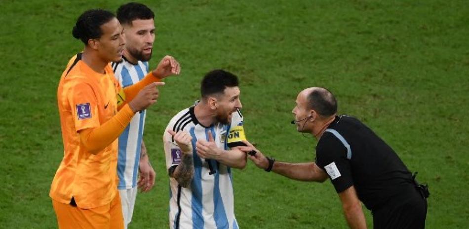El delantero argentino Lionel Messi  discute con el árbitro español Antonio Mateu durante el partido de fútbol de cuartos de final de la Copa Mundial de Qatar 2022 entre Holanda y Argentina.