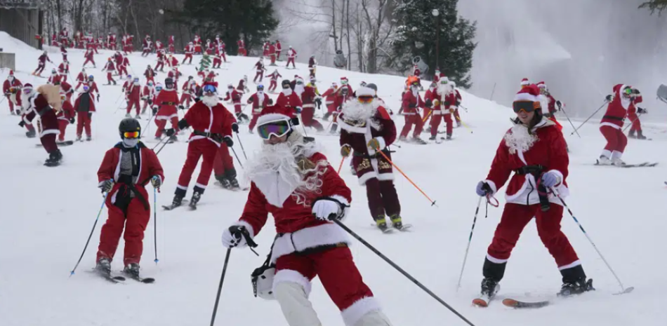 Personas disfrazadas de Santa Claus esquian en un evento caritativo en Sunday River Ski Resort, en Newry, Maine, el 11 de diciembre de 2022. AP
