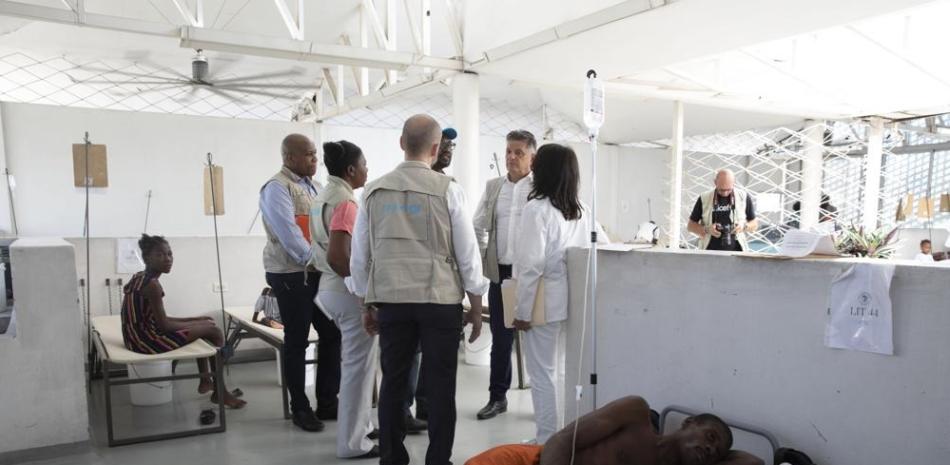 Pacientes con síntomas de cólera descansan en el Centro Gheskio mientras Manuel Fontaine, director de la Oficina de Programas de Emergencia de UNICEF, de espaldas a la cámara, visita el centro en Puerto Príncipe, Haití, el lunes 21 de noviembre de 2022. AP