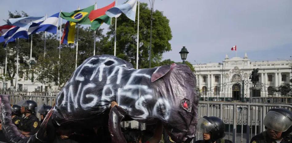 Partidarios del derrocado presidente Pedro Castillo llevan una rata inflada que dice en español: Pase “Cerrar el Congreso” frente al Congreso en Lima, el domingo pasado. AP