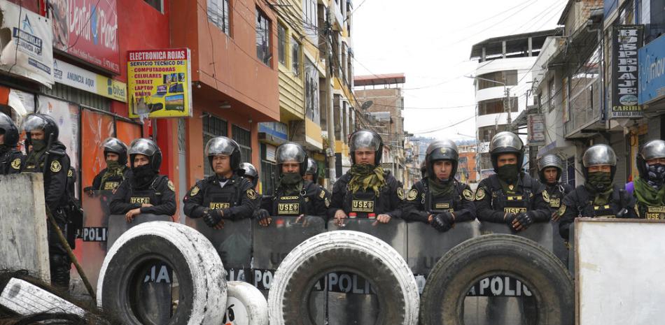 La policía hace guardia detrás de una barricada, un día después de las protestas en contra de la nueva presidenta de Perú, Dina Boluarte, en Andahuaylas, Perú, el lunes 12 de diciembre de 2022. AP.