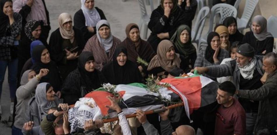 Palestinos cargan el cuerpo de Jana Zakran, de 16 años, durante su funeral en la ciudad de Jenin, Cisjordania, ayer lunes AP