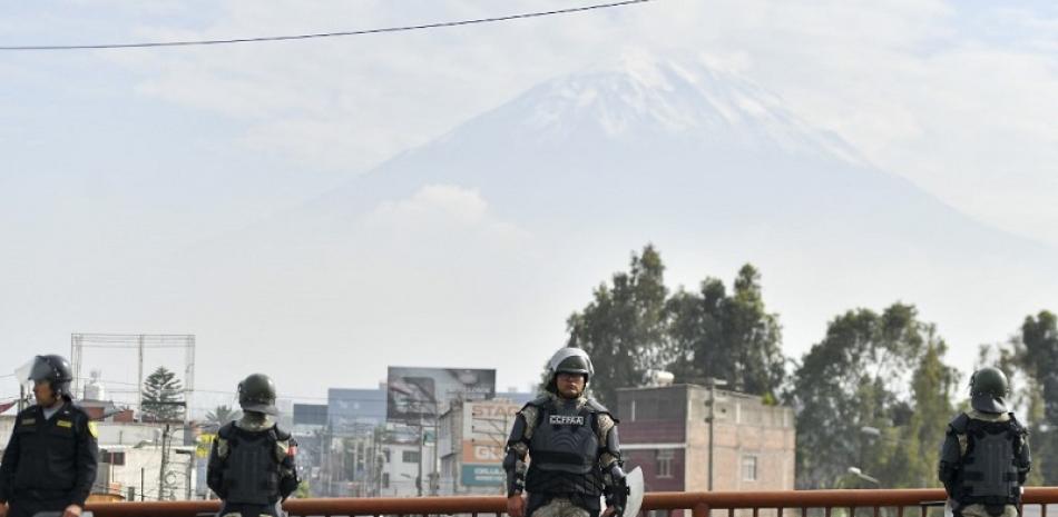 Elementos de la policía custodian una calle tras la declaratoria de emergencia nacional realizada por el nuevo Gobierno de Perú en Arequipa, Perú. Foto de AFP