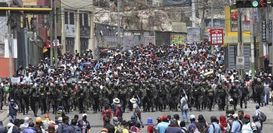 La policía llega hasta donde los seguidores del destituido presidente peruano Pedro Castillo protestan por su detención en Arequipa, ayer miércoles. ap
