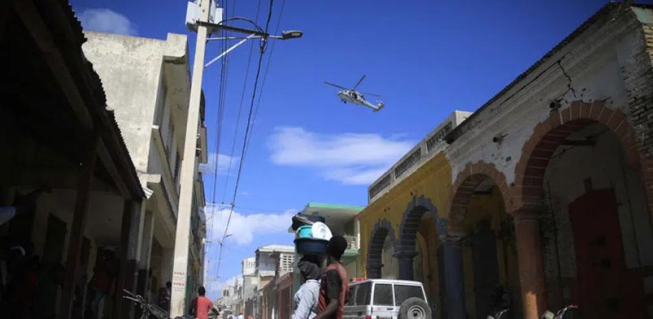 Un helicóptero USN sobrevuela durante una protesta contra la llegada del barco hospital USNS Comfort en Jeremie, el martes pasado. AP