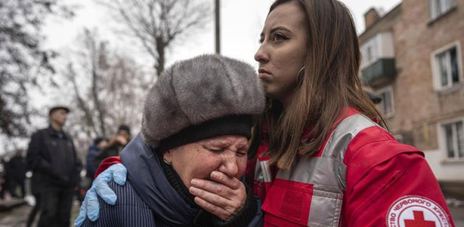 Una mujer llora frente a un edificio destruido en el ataque en Kiev, ayer. AP
